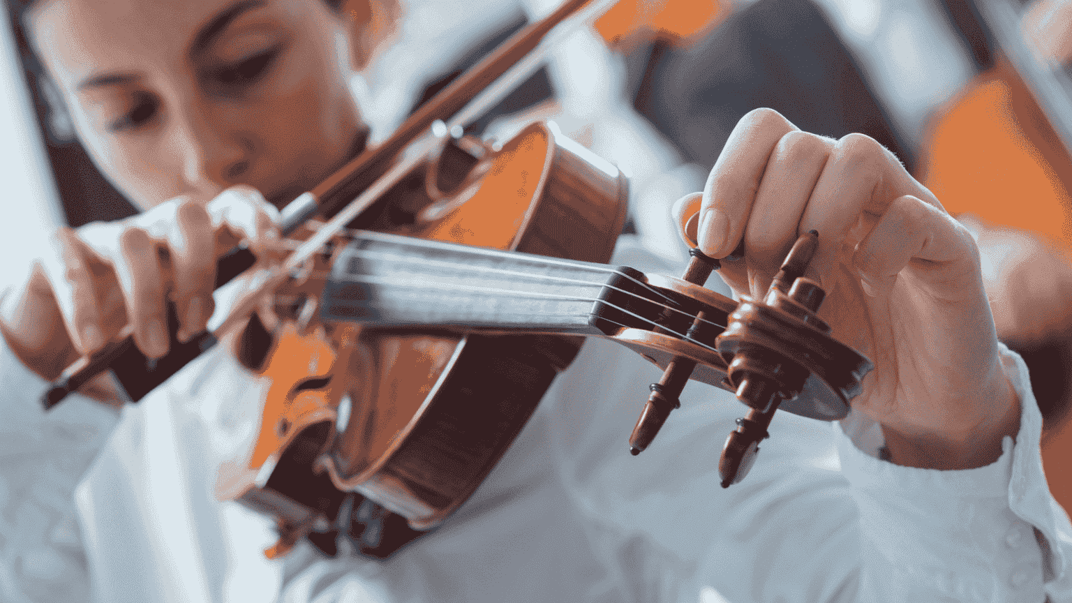 عکس یک خانم در حال کوک کردن ویولن